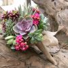 Green and purple succulent bouquet with fuchsia accents.
