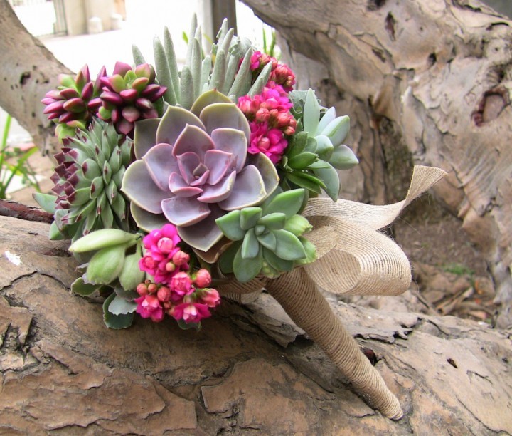 Green and purple succulent bouquet with fuchsia accents.